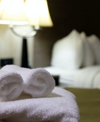 White bath towel on bed in hotel room